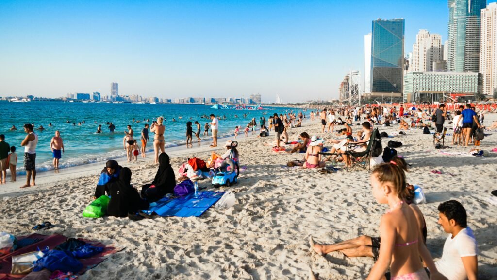 pexels-photo-1040795-1040795 Bustling beach in Dubai with people enjoying the sun and city skyline in the background.