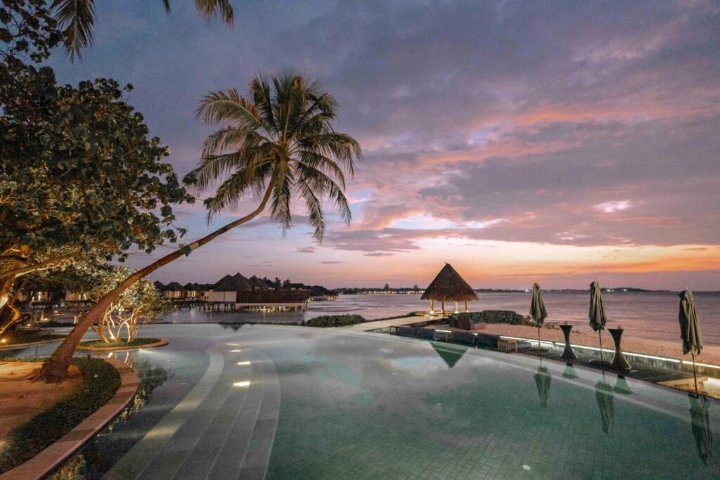 pexels-photo-11434425-11434425 Elegant beach resort with palm trees and infinity pool at sunset, perfect for a romantic getaway.