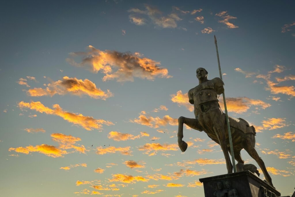 pexels-photo-14754619-14754619 A majestic centaur statue against a vibrant sunset sky in Pompeii, Italy.