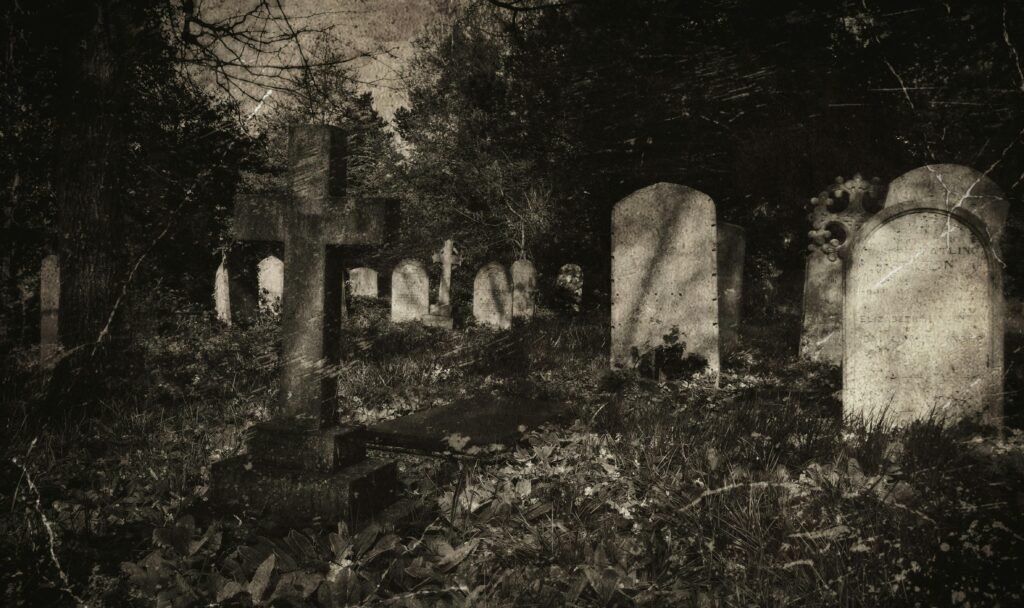 Eerie vintage-style photograph of an old cemetery with gravestones and cross under shadows.