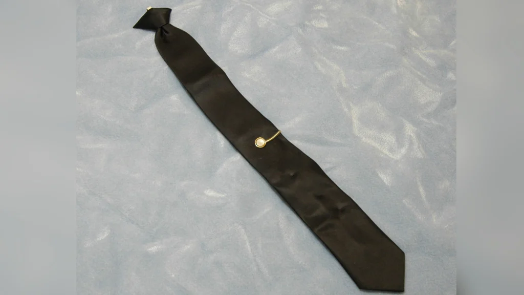 D.B.-Cooper-Clip-On-Tie-Microscopic-Particles Close-up image of the black clip-on tie left by D.B. Cooper, highlighting the area analyzed for microscopic metal particles and DNA evidence.