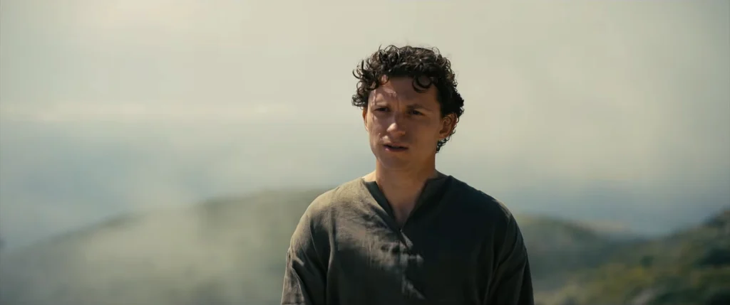 4.	Split image showing Tom Holland looking out to sea and Anne Hathaway weaving a tapestry, representing the family waiting in Ithaca.